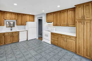 Kitchen featuring sink, light tile patterned floors, and white appliances