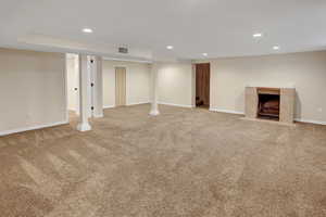 Basement featuring light carpet and a tile fireplace