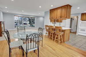 Dining space with crown molding, sink, and light hardwood / wood-style floors