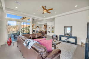 Living area with ceiling fan with notable chandelier, baseboards, visible vents, and recessed lighting