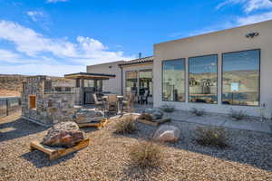 Rear view of property featuring a patio, stucco siding, fence, and a tile roof