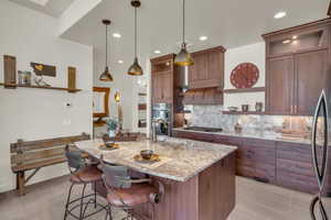 Kitchen featuring open shelves, a sink, stainless steel appliances, decorative backsplash, and light stone counters