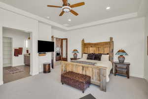 Bedroom featuring baseboards, a raised ceiling, a ceiling fan, recessed lighting, and light colored carpet