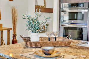 Kitchen featuring light stone countertops and stainless steel double oven