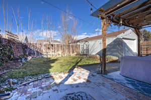 View of yard with an outbuilding, a garage, and a patio