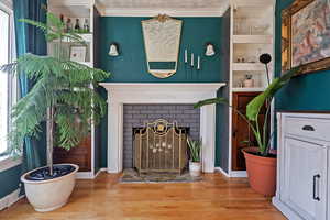 Details featuring ornamental molding, a fireplace, and hardwood / wood-style floors