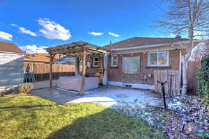 Rear view of house with a pergola, a yard, and a patio area