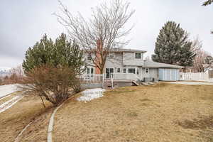 Rear view of property with a shed, central AC unit, a yard, and a deck