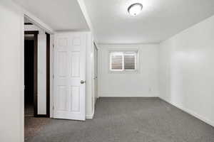 Unfurnished bedroom with carpet and a textured ceiling