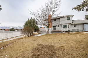 Rear view of property featuring central AC, a lawn, and a deck with mountain view