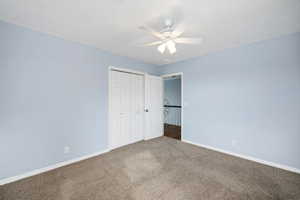 Unfurnished bedroom featuring carpet floors, ceiling fan, and a closet