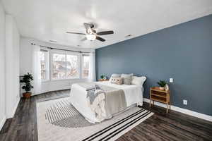 Bedroom with dark wood-type flooring and ceiling fan