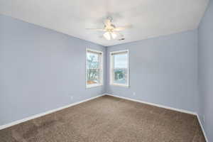 Carpeted spare room with ceiling fan