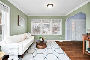 Living room with ornamental molding and wood-type flooring