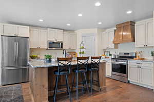 Large kitchen island with sink. Custom cabinetry surrounds the bar stools to keep everything tucked in and nice.