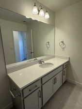 Bathroom with visible vents, vanity, baseboards, and tile patterned floors