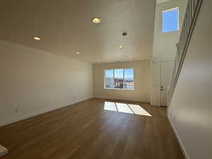 Spare room featuring a textured ceiling, baseboards, wood finished floors, and recessed lighting