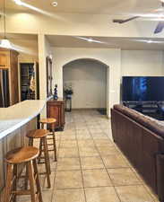 Interior space with ceiling fan and indoor bar