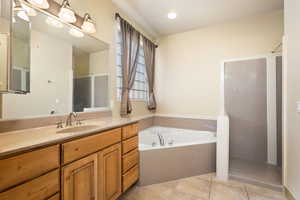 Full bath with a shower stall, tile patterned floors, a garden tub, and vanity