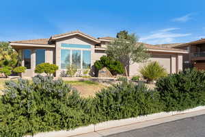 View of front of house featuring an attached garage and stucco siding