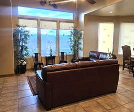 Living room featuring light tile patterned flooring and ceiling fan