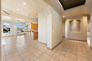Interior space with recessed lighting, arched walkways, light tile patterned floors, and a kitchen breakfast bar