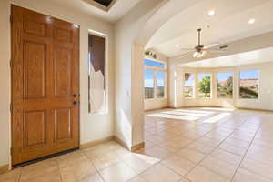 Foyer entrance with baseboards, recessed lighting, a ceiling fan, light tile patterned flooring, and arched walkways