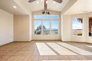 Empty room with a ceiling fan, visible vents, recessed lighting, light tile patterned flooring, and lofted ceiling