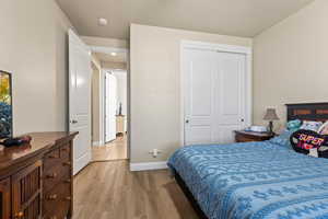 Bedroom with light wood-type flooring and a closet