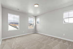 Unfurnished room with light carpet and a textured ceiling