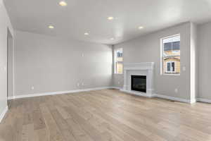 Unfurnished living room with light hardwood / wood-style floors and a textured ceiling