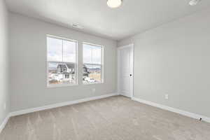 Unfurnished room featuring carpet flooring and a textured ceiling