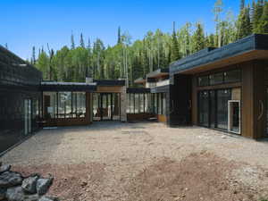 Rear view of property featuring a wooded view