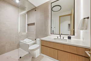 Full bathroom featuring tile walls, vanity, a walk in shower, and light tile patterned flooring
