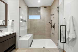 Full bathroom featuring walk in shower, vanity, and tile walls
