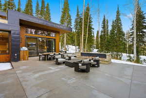 Snow covered patio with a patio and an outdoor living space with a fire pit