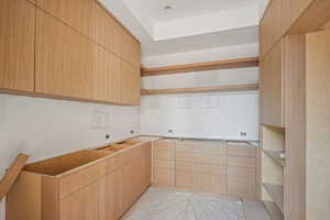 Kitchen featuring open shelves, light brown cabinets, and modern cabinets