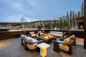 View of patio with a forest view and an outdoor living space with a fire pit