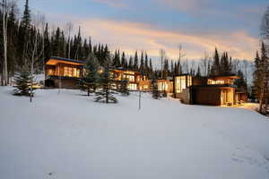Snow covered back of property with a balcony