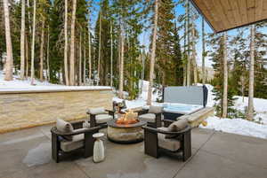 Snow covered patio with a patio area and an outdoor fire pit