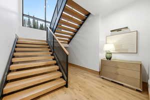 Staircase featuring baseboards and wood finished floors