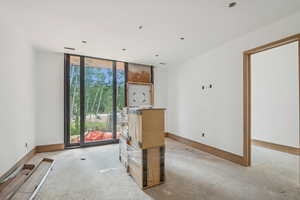 Unfurnished room featuring floor to ceiling windows and concrete flooring