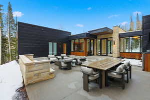 Rear view of property with an outdoor living space, a patio area, outdoor dining space, and a sunroom