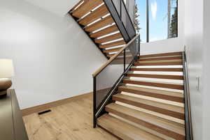 Stairway featuring wood finished floors and baseboards