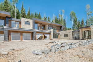 View of front of house with stone siding and an attached garage
