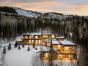 Snow covered house with a view of trees and a balcony