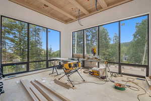 Unfurnished sunroom featuring a wood ceiling with exposed beams