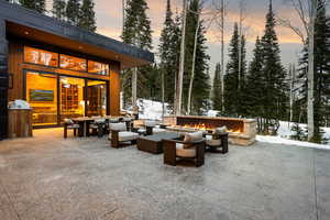 Snow covered patio featuring a patio area and an outdoor living space with a fire pit