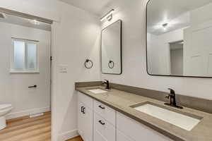 Bathroom featuring vanity, hardwood / wood-style floors, and toilet