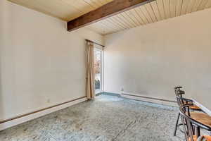 Carpeted spare room featuring wood ceiling, beam ceiling, and a baseboard radiator